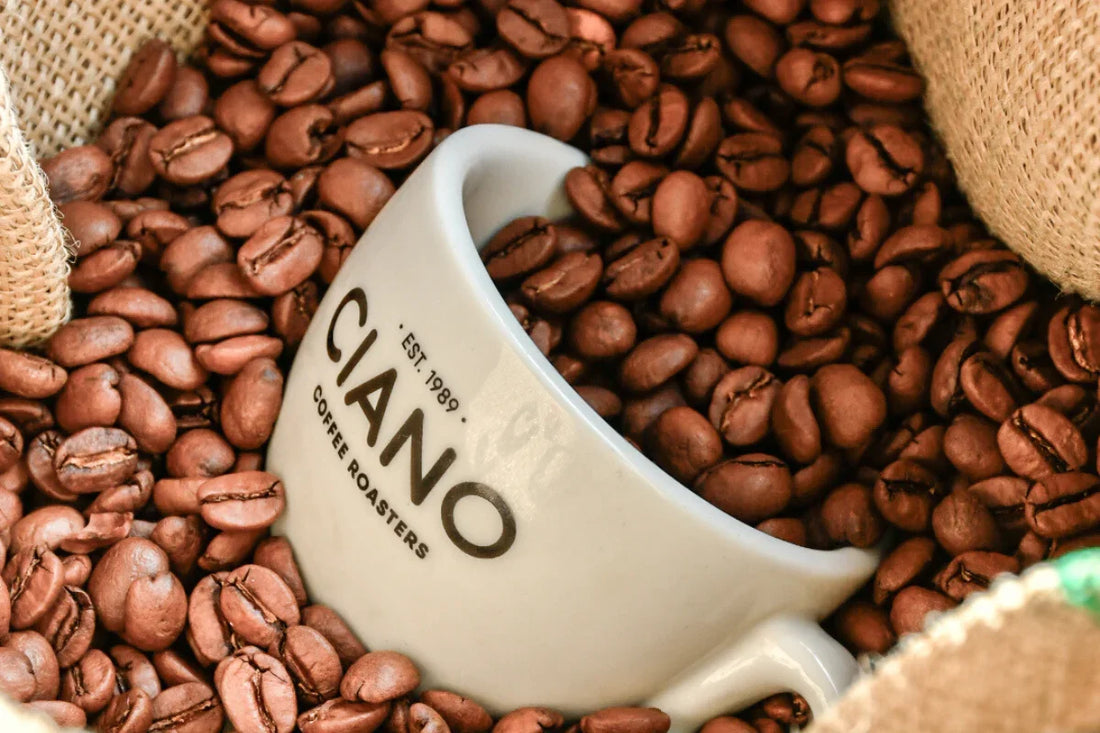 taza de cafe de ciano llena de granos de cafe arabicos