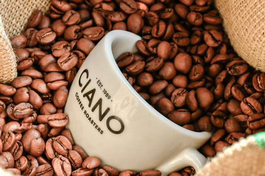 taza de cafe de ciano llena de granos de cafe arabicos