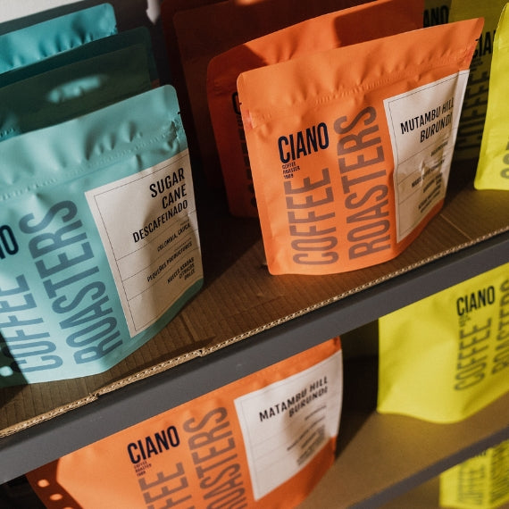 Estantería repleta de bolsas de café de especialidad, organizada por variedades y orígenes