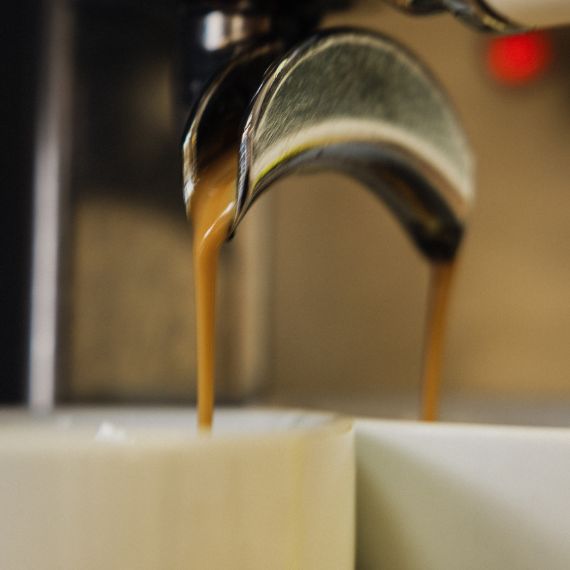 Portafiltros bien ajustado echando café espresso de forma uniforme, listo para la extracción perfecta